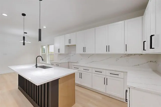 a kitchen with granite countertop a sink a counter top space appliances and cabinets