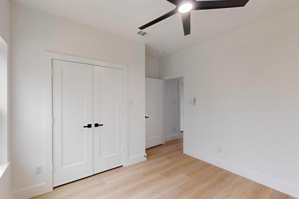 4515 Wahoo Street Dallas, TX 75210 - Photo 28 of 36 Unfurnished bedroom featuring light wood-style flooring, a closet, and ceiling fan