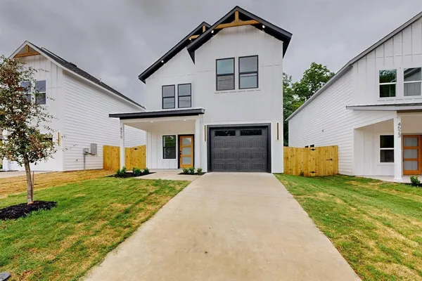 a front view of a house with a yard and trees