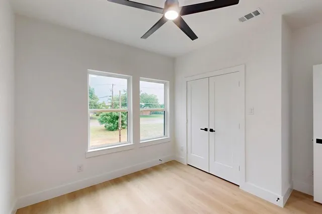 an empty room with a window and a fan
