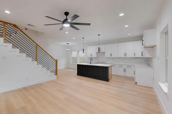 a kitchen with stainless steel appliances kitchen island a cabinets and wooden floor