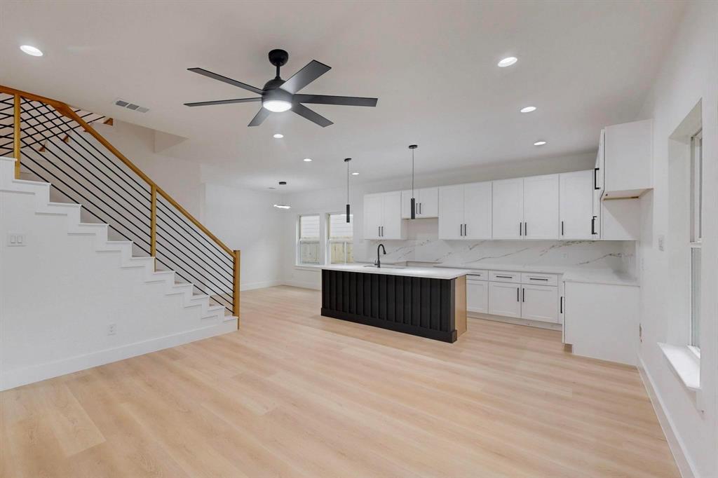 4515 Wahoo Street Dallas, TX 75210 - Photo 10 of 36 Kitchen featuring an island with sink, light wood-type flooring, decorative backsplash, light countertops, and recessed lighting