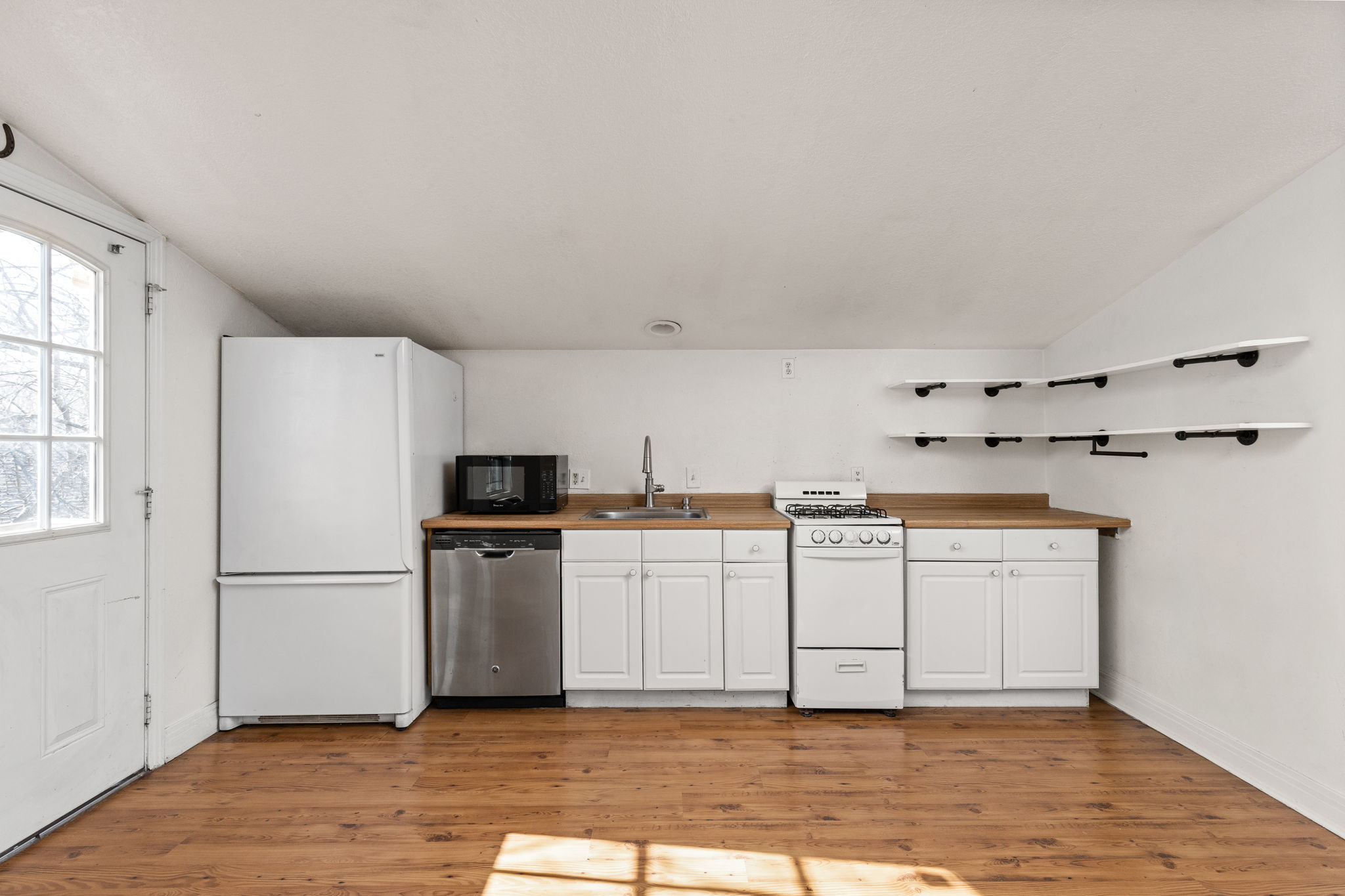 2203 Lindell Avenue Austin, TX 78704 - Photo 29 of 39 Kitchen featuring white cabinetry, vaulted ceiling, white appliances, light wood-type flooring, and open shelves