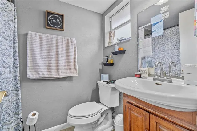 a bathroom with a sink a toilet and a mirror