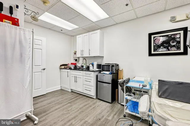 a kitchen with a refrigerator and white cabinets