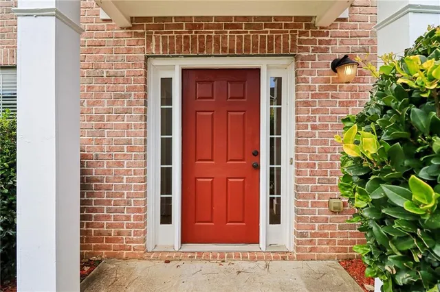a view of a hallway with wooden floor and a bathroom