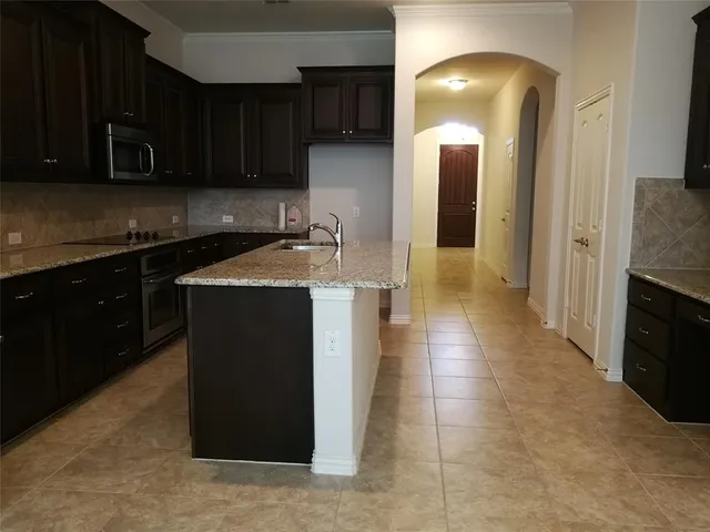 a kitchen with stainless steel appliances granite countertop a stove a sink and a microwave