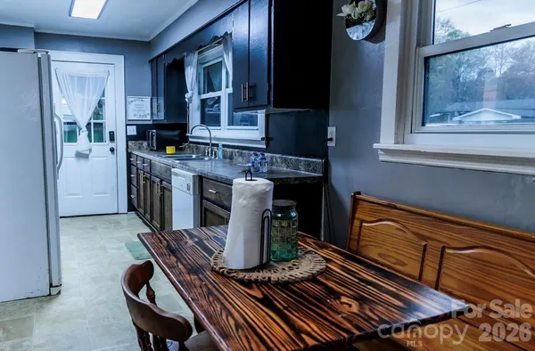 a kitchen with a table chairs and a refrigerator