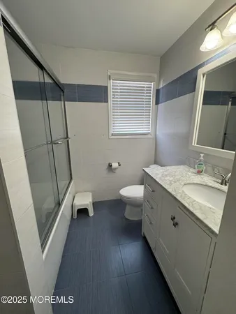 a bathroom with a sink a toilet and a mirror