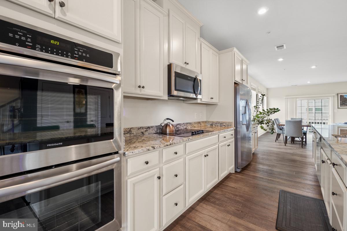 2945 Duvall Ridge Road, Unit 573 Hyattsville, MD 20785 - Photo 3 of 23 a kitchen with stainless steel appliances kitchen island granite countertop a stove a sink and a microwave