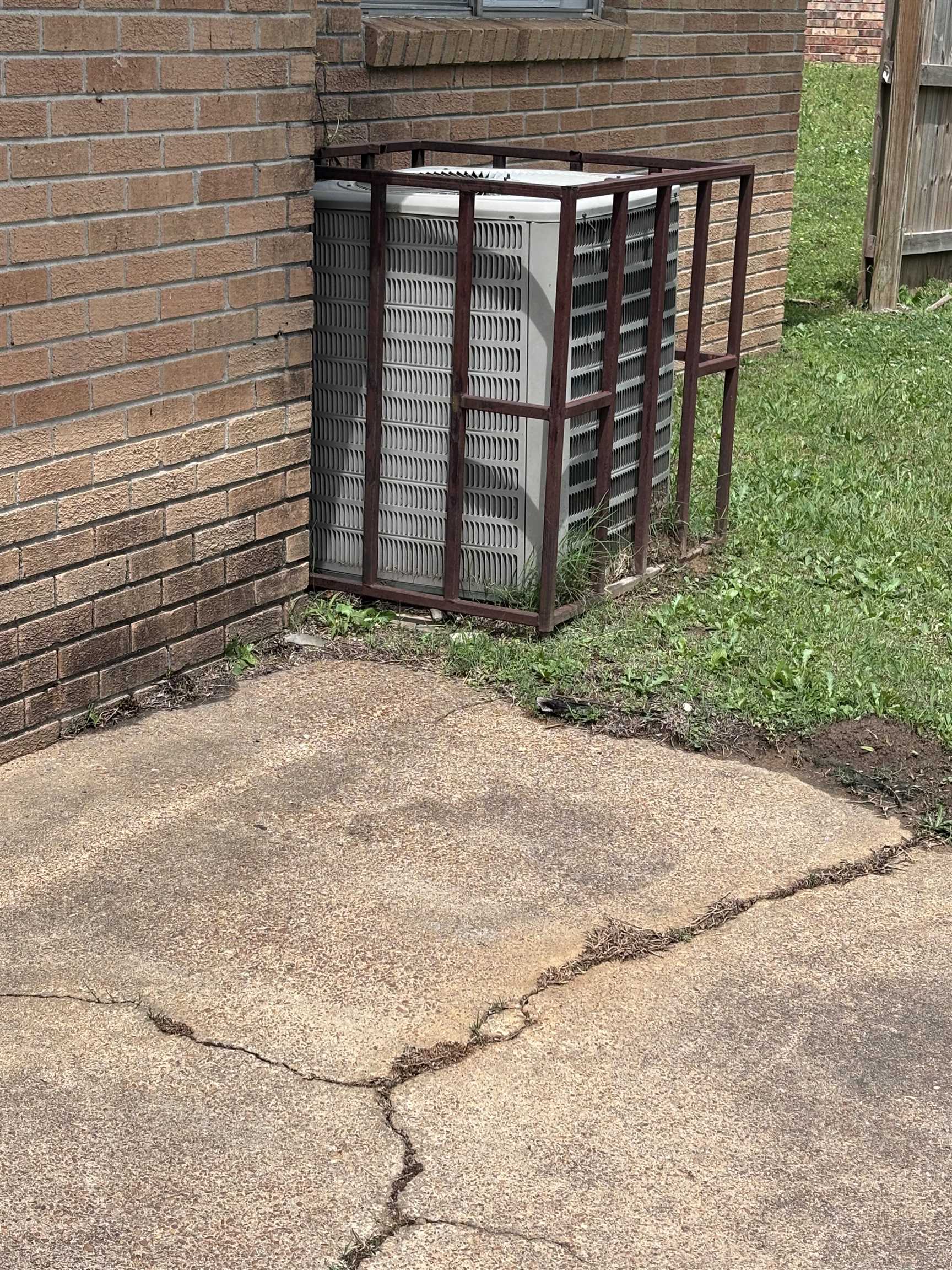 3021 Meadowfair Road Memphis, TN 38118 - Photo 3 of 3 Exterior brick wall with a secured air conditioning unit, adjacent to a concrete patio surface