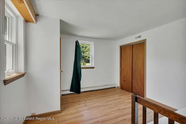 a view of a hallway with wooden floor and staircase