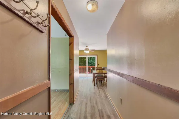 a view of a hallway with wooden floor and furniture