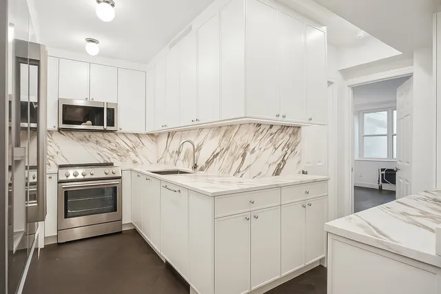a view of a kitchen with a sink and a refrigerator