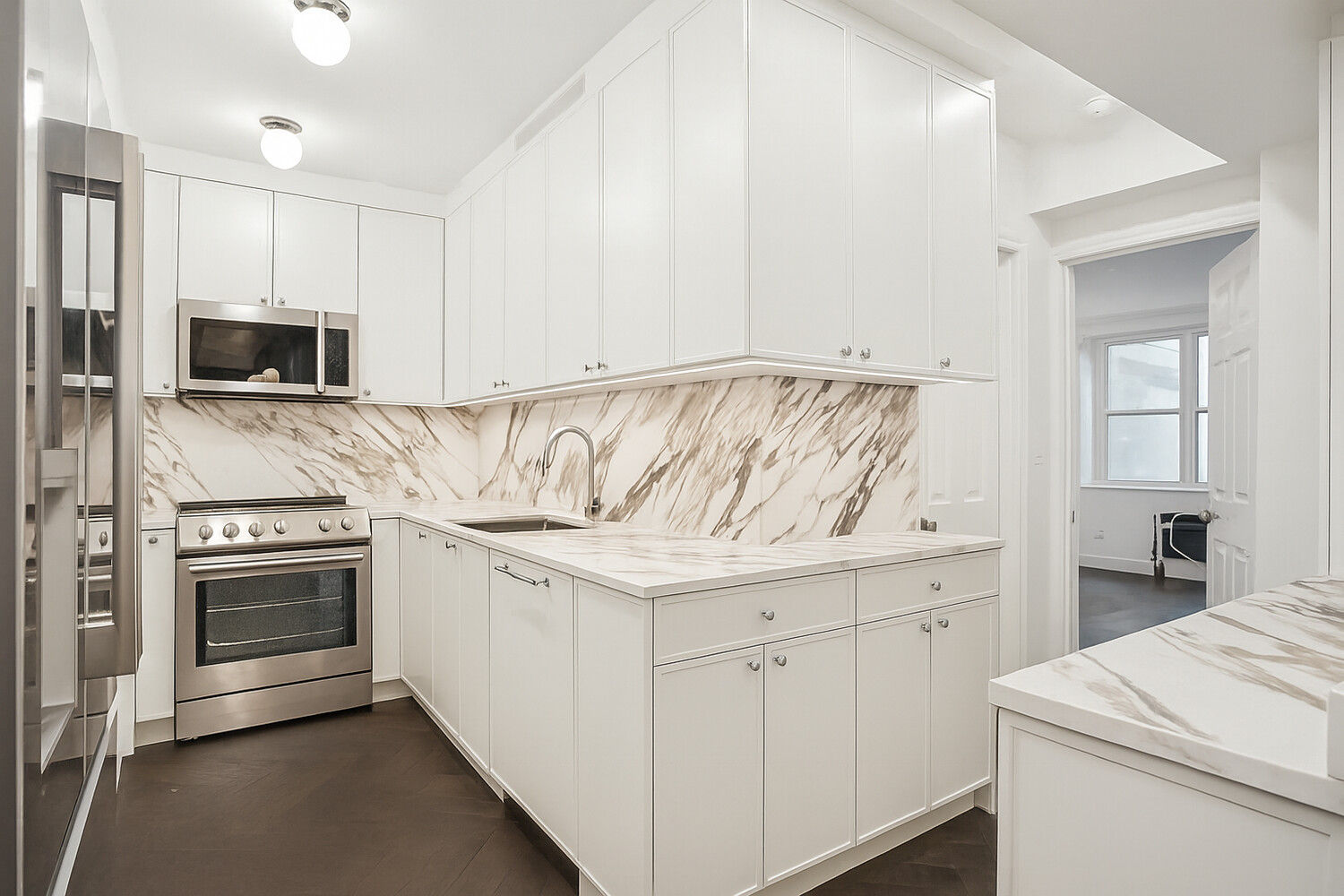 116 East 66th Street, Unit 3E Manhattan, NY 10065 - Photo 4 of 10 a kitchen with white cabinets and stainless steel appliances
