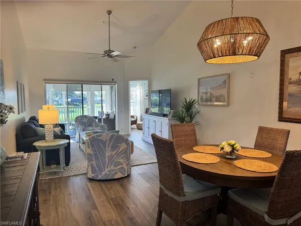 a living room with furniture a chandelier and a wooden floor