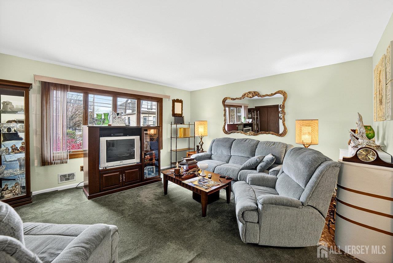 307 Sutton Street Perth Amboy, NJ 08861 - Photo 17 of 27 a living room with furniture a flat screen tv and a fireplace