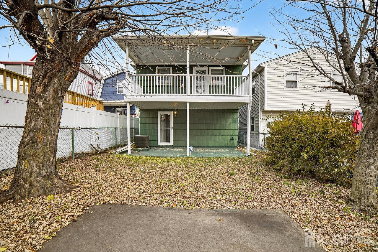 307 Sutton Street Perth Amboy, NJ 08861 - Photo 25 of 27 front view of a house with a large window and potted plants