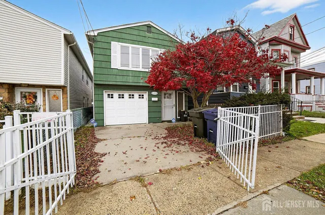 a view of a brick house with a small yard and wooden fence
