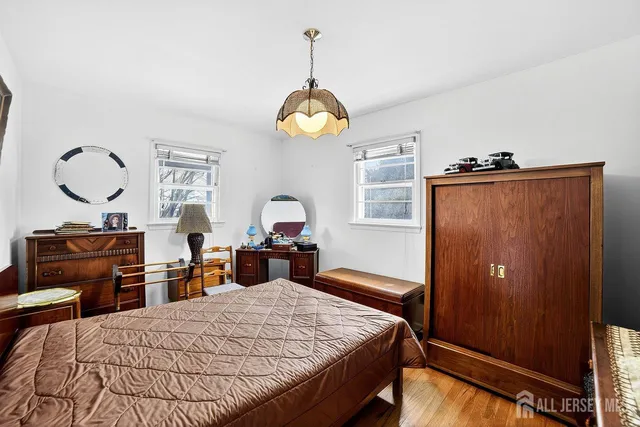 a bedroom with a bed and dresser with mirror