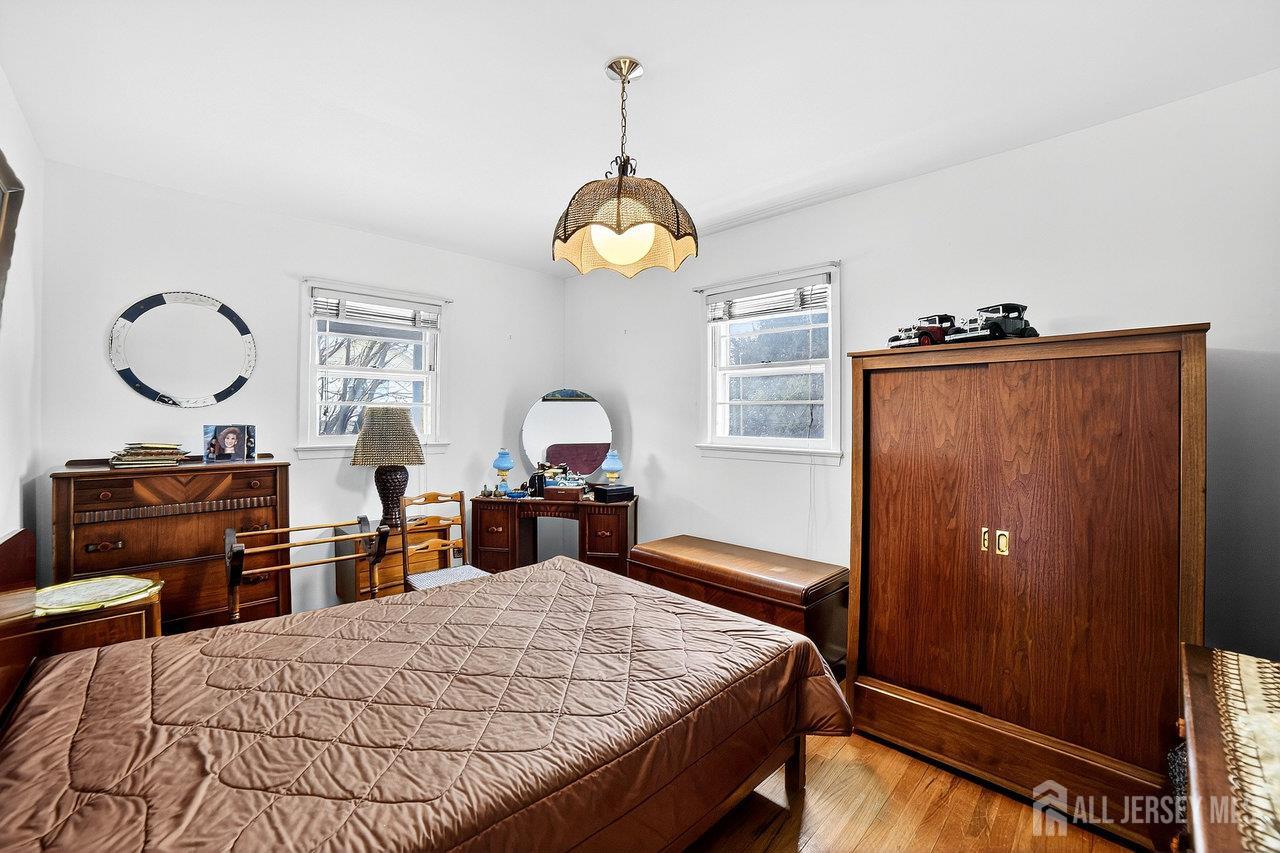 307 Sutton Street Perth Amboy, NJ 08861 - Photo 7 of 27 a bedroom with a bed and dresser with mirror