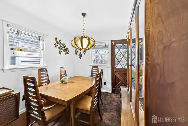 a view of a dining room and a livingroom with furniture wooden floor a chandelier