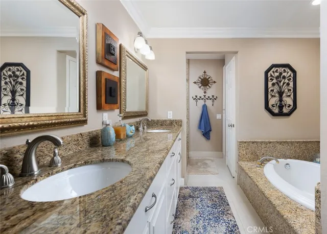 a bathroom with a granite countertop tub sink and mirror