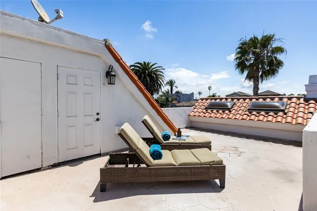 a view of a terrace with couches and wooden fence