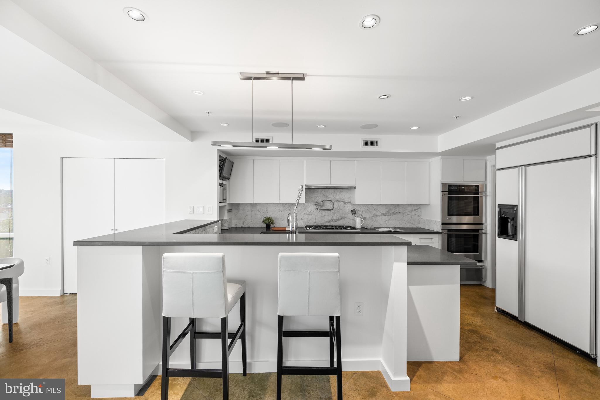 2002 Massachusetts Avenue Northwest, Unit R3 Washington, DC 20036 - Photo 4 of 27 a kitchen with stainless steel appliances granite countertop a sink a stove a refrigerator and white cabinets with wooden floor