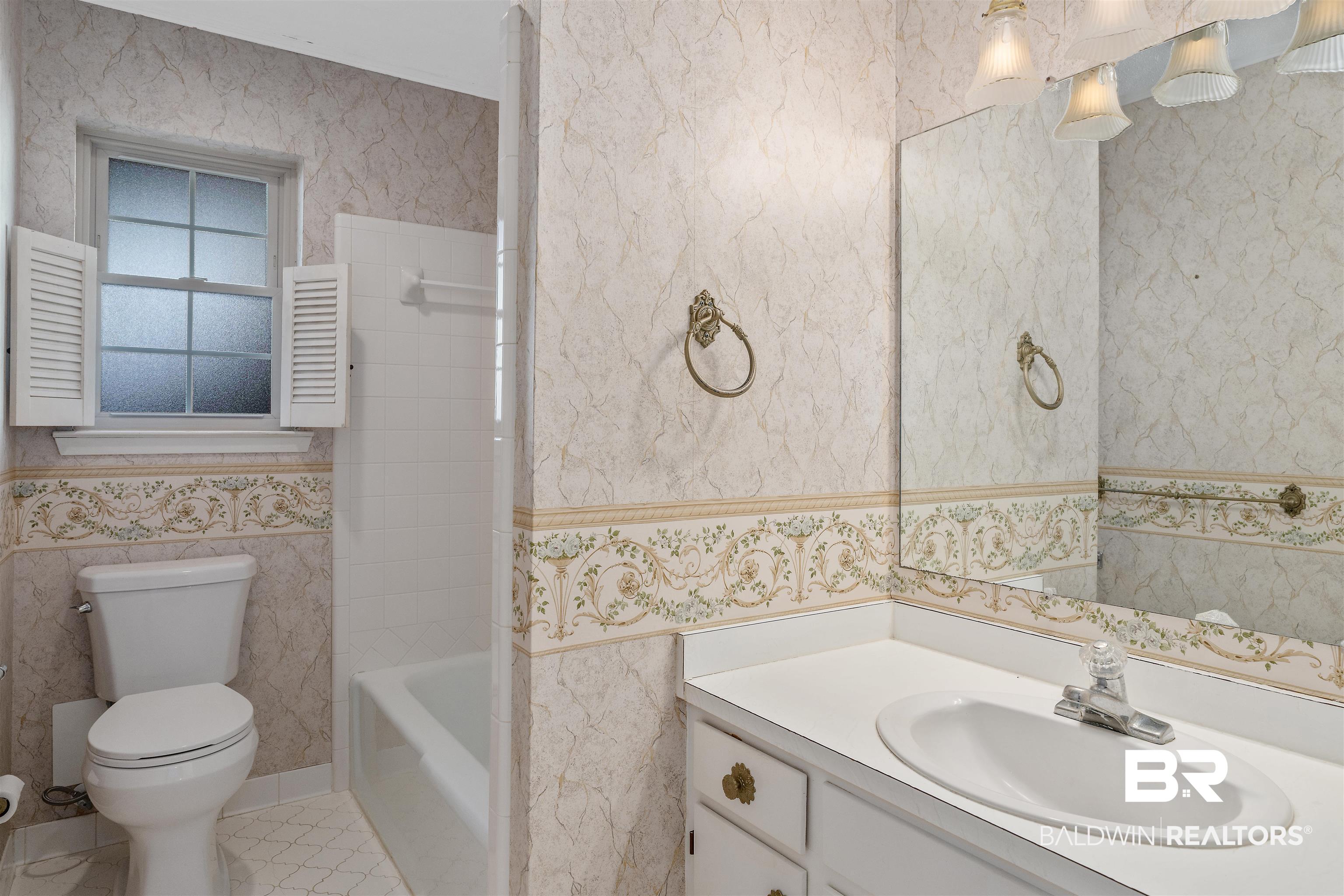 621 Spanish Main Spanish Fort, AL 36527 - Photo 26 of 29 Bathroom featuring tile patterned flooring, vanity, tile walls, and toilet