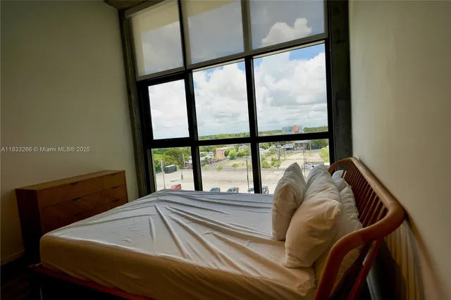 a bed sitting in a bedroom next to a large window