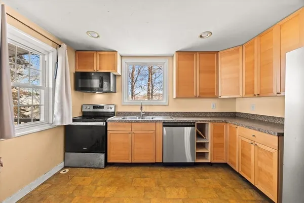 a kitchen with stainless steel appliances granite countertop a stove a sink and a microwave