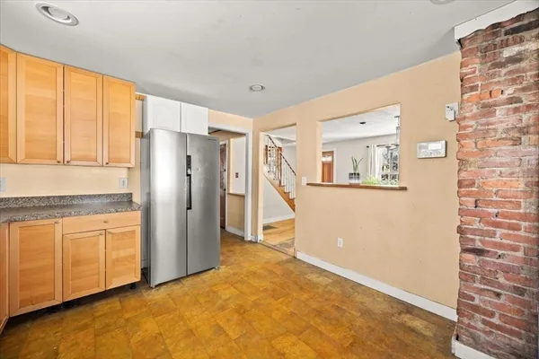 a view of a kitchen with wooden cabinet and a refrigerator