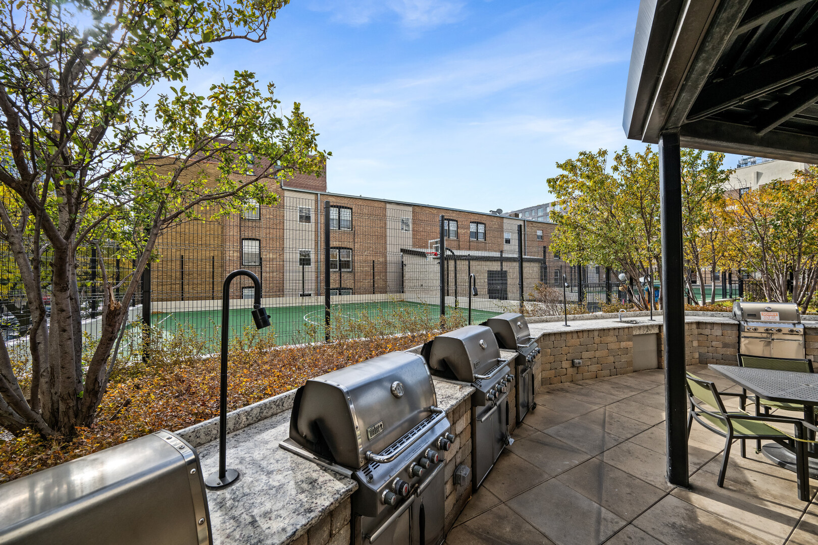 3930 North Pine Grove Avenue, Unit 1109 Chicago, IL 60613 - Photo 12 of 24 a view of backyard with couches under an umbrella