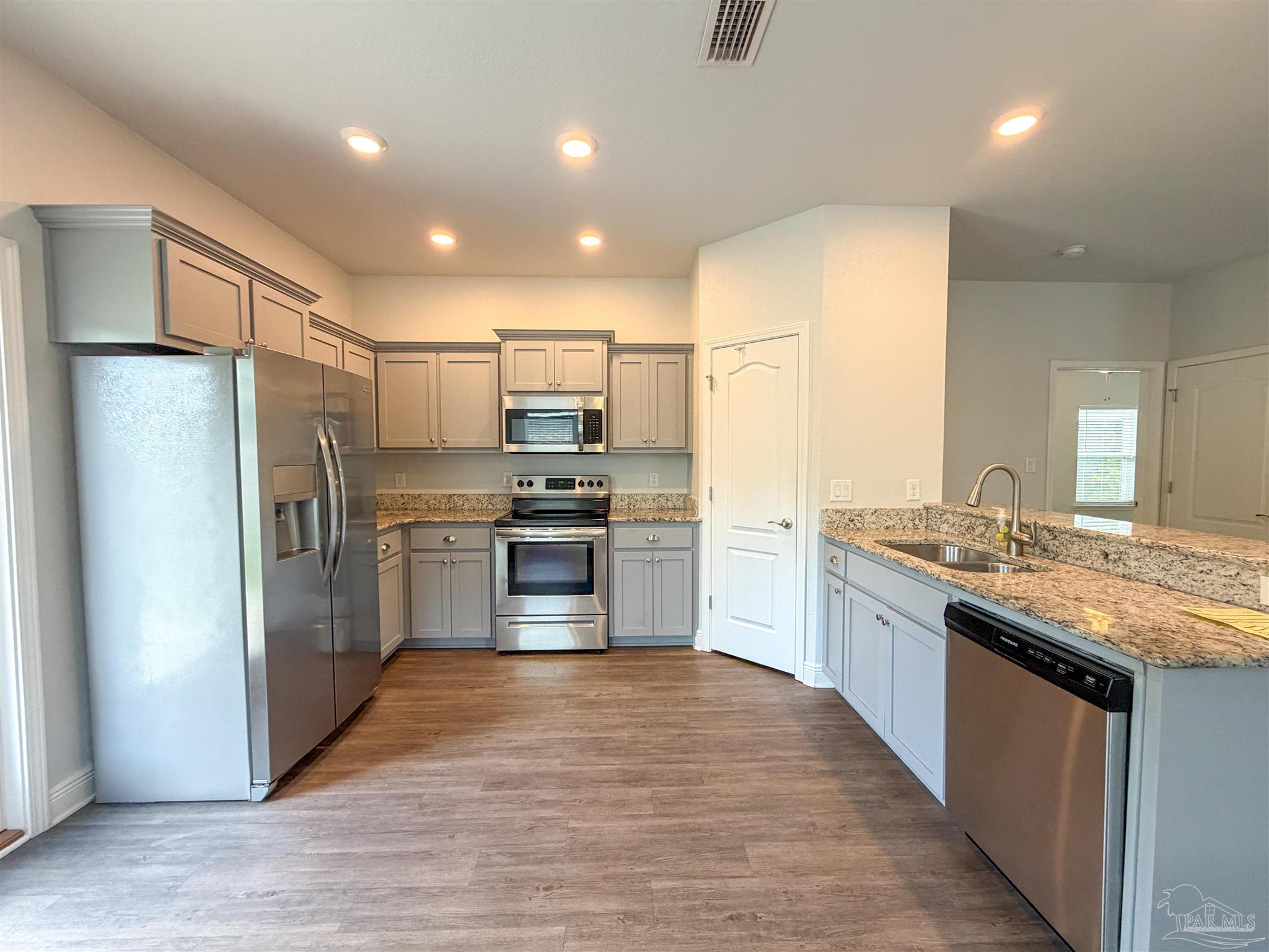 3613 Conley Drive Cantonment, FL 32533 - Photo 6 of 32 a kitchen with stainless steel appliances granite countertop a refrigerator a sink and a stove