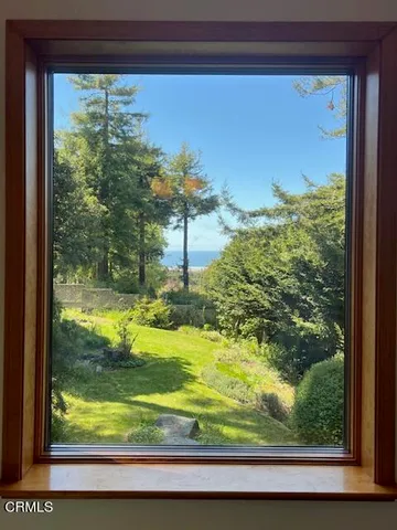 a view of an empty room with a fireplace and a window