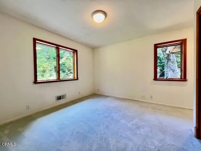 a living room with furniture a flat screen tv and a floor to ceiling window