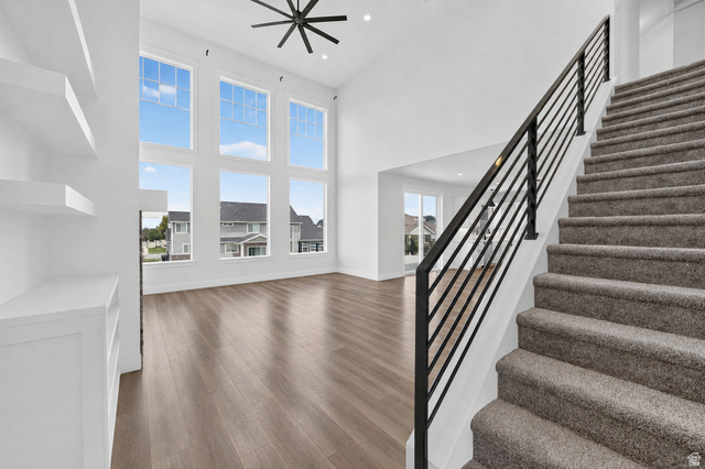 1002 West Temple Rim Lane Payson, UT 84651 - Photo 10 of 68 Bright living space featuring a two-story window wall, wood-finish flooring, and a contemporary ceiling fan