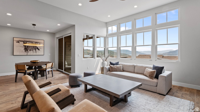 355 East Overlook Loop Hideout, UT 84036 - Photo 3 of 40 Expansive living area featuring a wall of multi-pane windows, wood-finish flooring, recessed lighting, and a contemporary dining space with a linear pendant light
