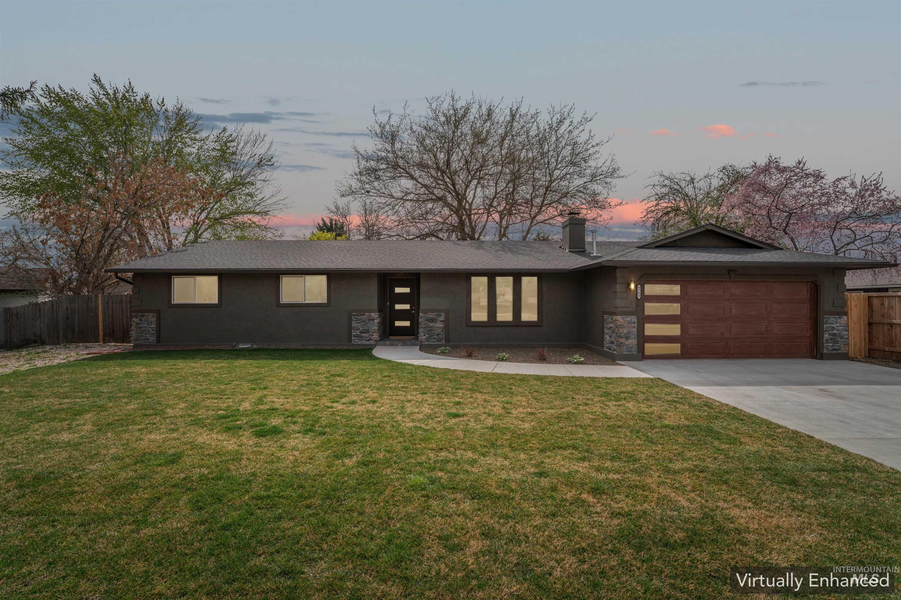 View of front of home with an attached garage, driveway, stone siding, and a chimney