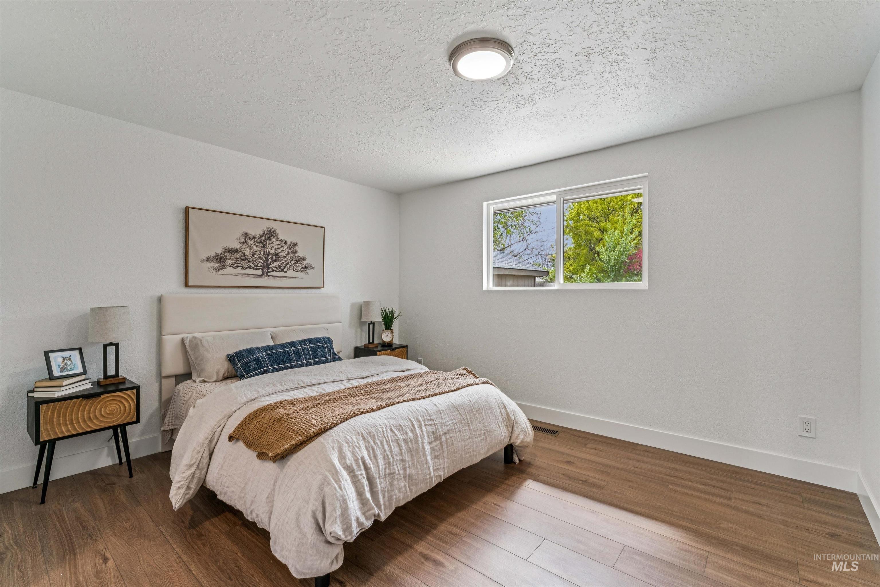 9709 West McMillan Road Boise, ID 83704 - Photo 22 of 50 Bedroom with wood finished floors and a textured ceiling
