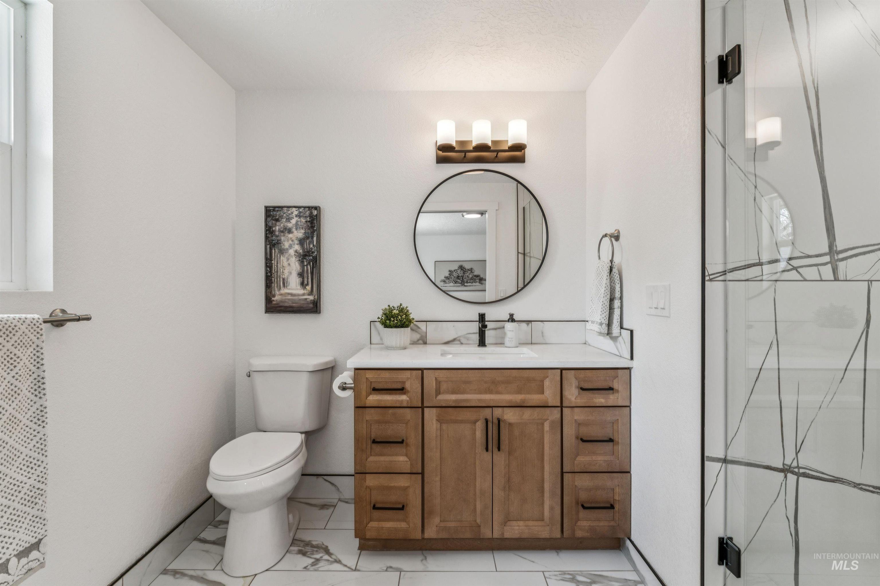 9709 West McMillan Road Boise, ID 83704 - Photo 26 of 50 Bathroom with vanity, light marble finish floors, and walk in shower