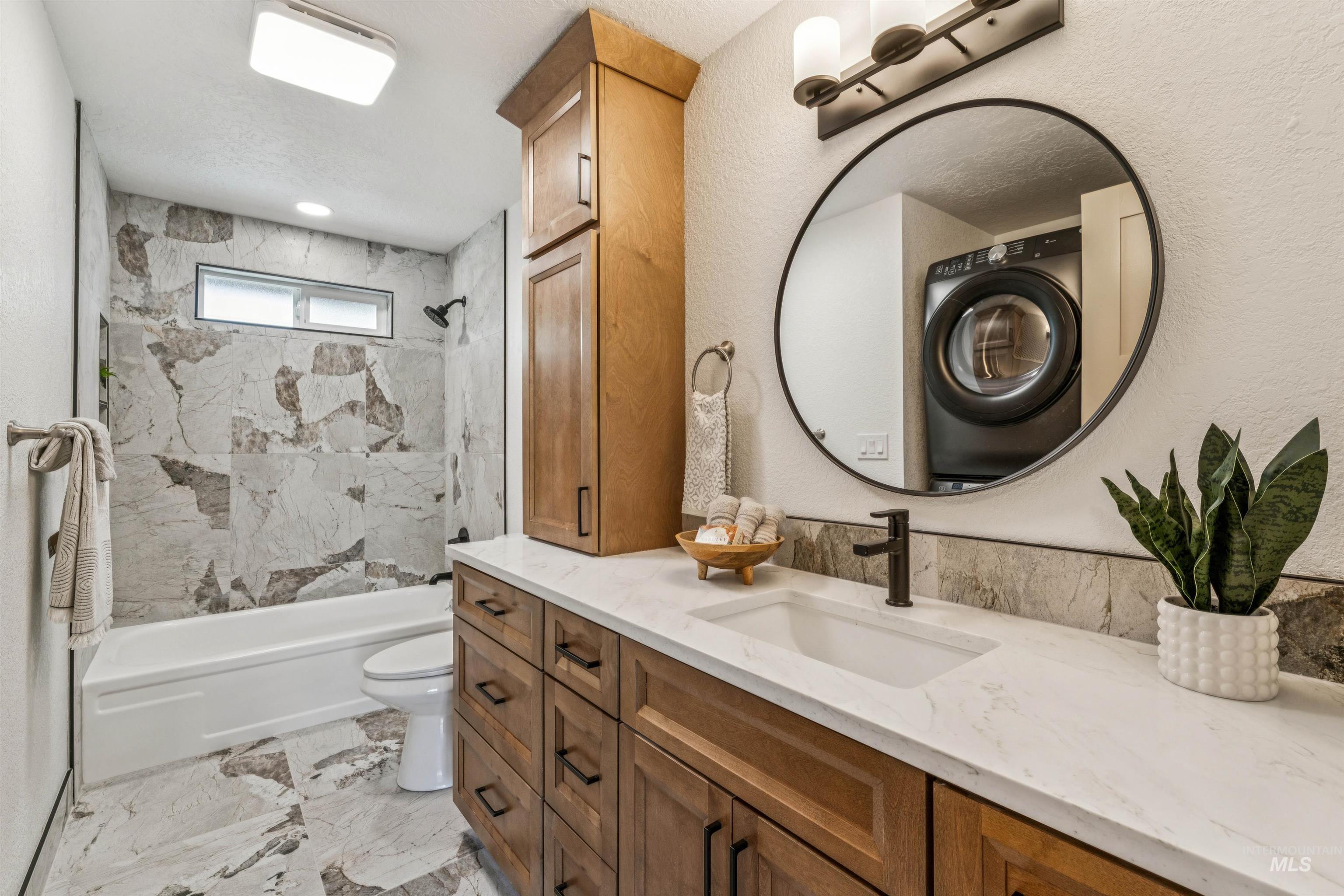 9709 West McMillan Road Boise, ID 83704 - Photo 30 of 50 Full bathroom featuring vanity, washer / clothes dryer, shower / bath combination, and light marble finish flooring