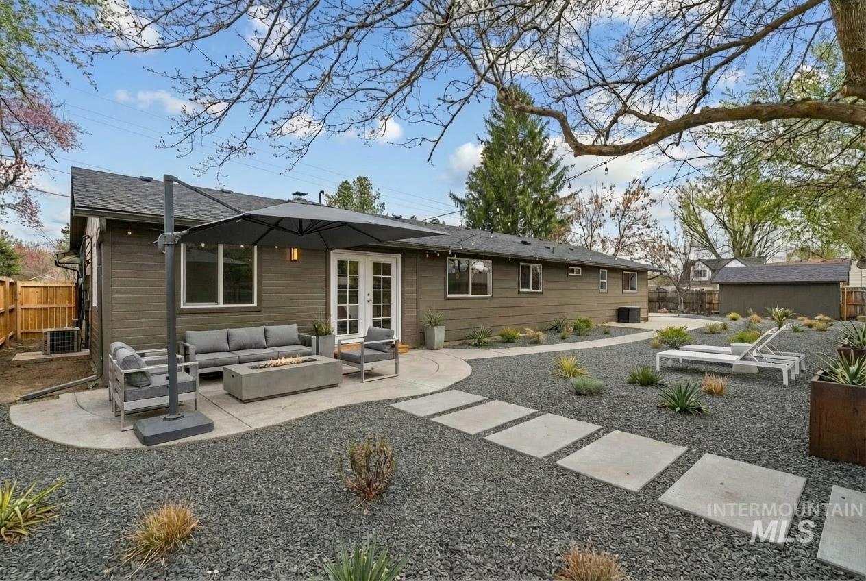 9709 West McMillan Road Boise, ID 83704 - Photo 34 of 50 Rear view of house with a patio area, an outdoor living space with a fire pit, a fenced backyard, and french doors