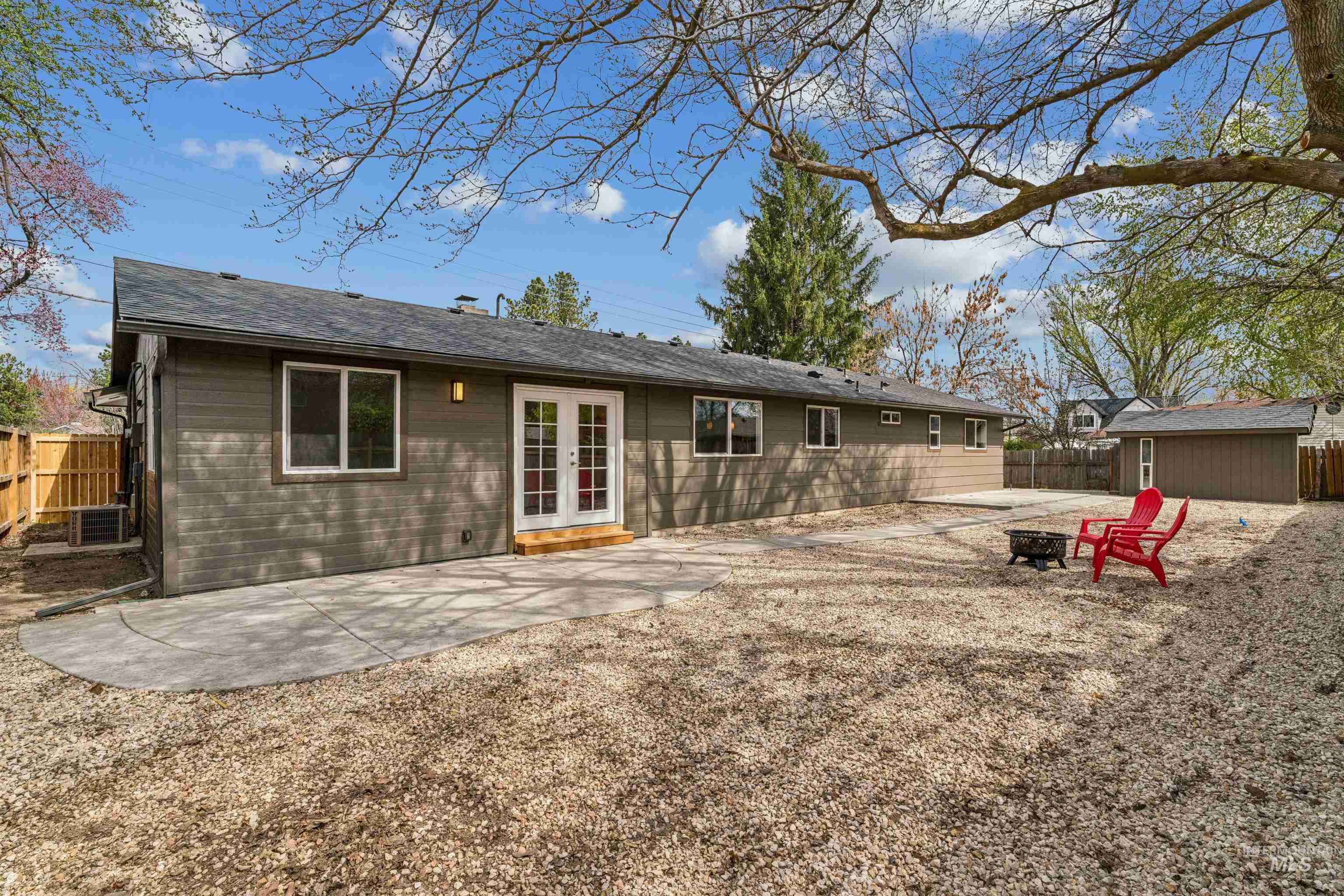 9709 West McMillan Road Boise, ID 83704 - Photo 36 of 50 Rear view of property featuring a patio, a fire pit, french doors, a fenced backyard, and an outbuilding