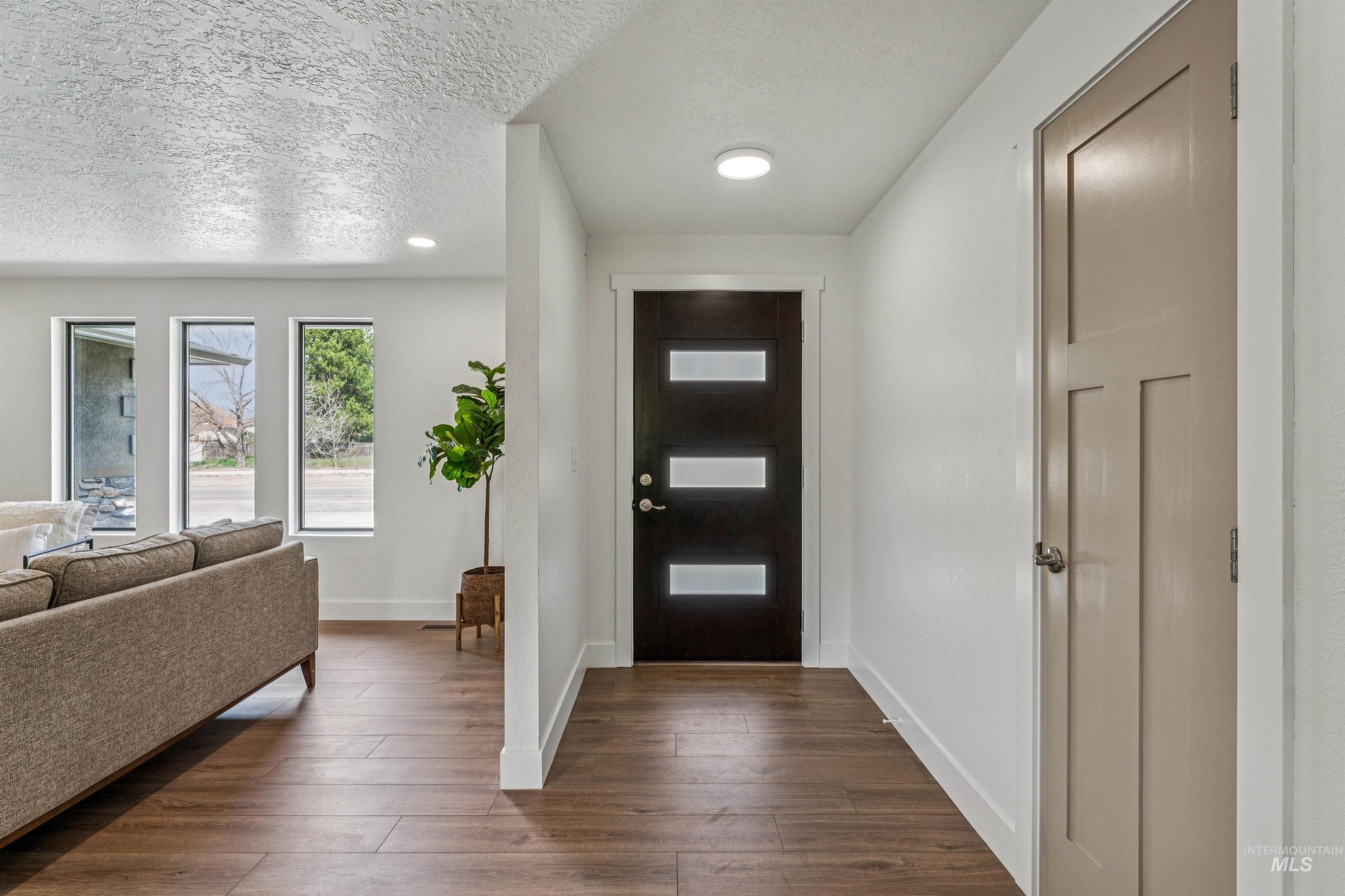9709 West McMillan Road Boise, ID 83704 - Photo 5 of 50 Entryway with dark wood-style flooring and a textured ceiling