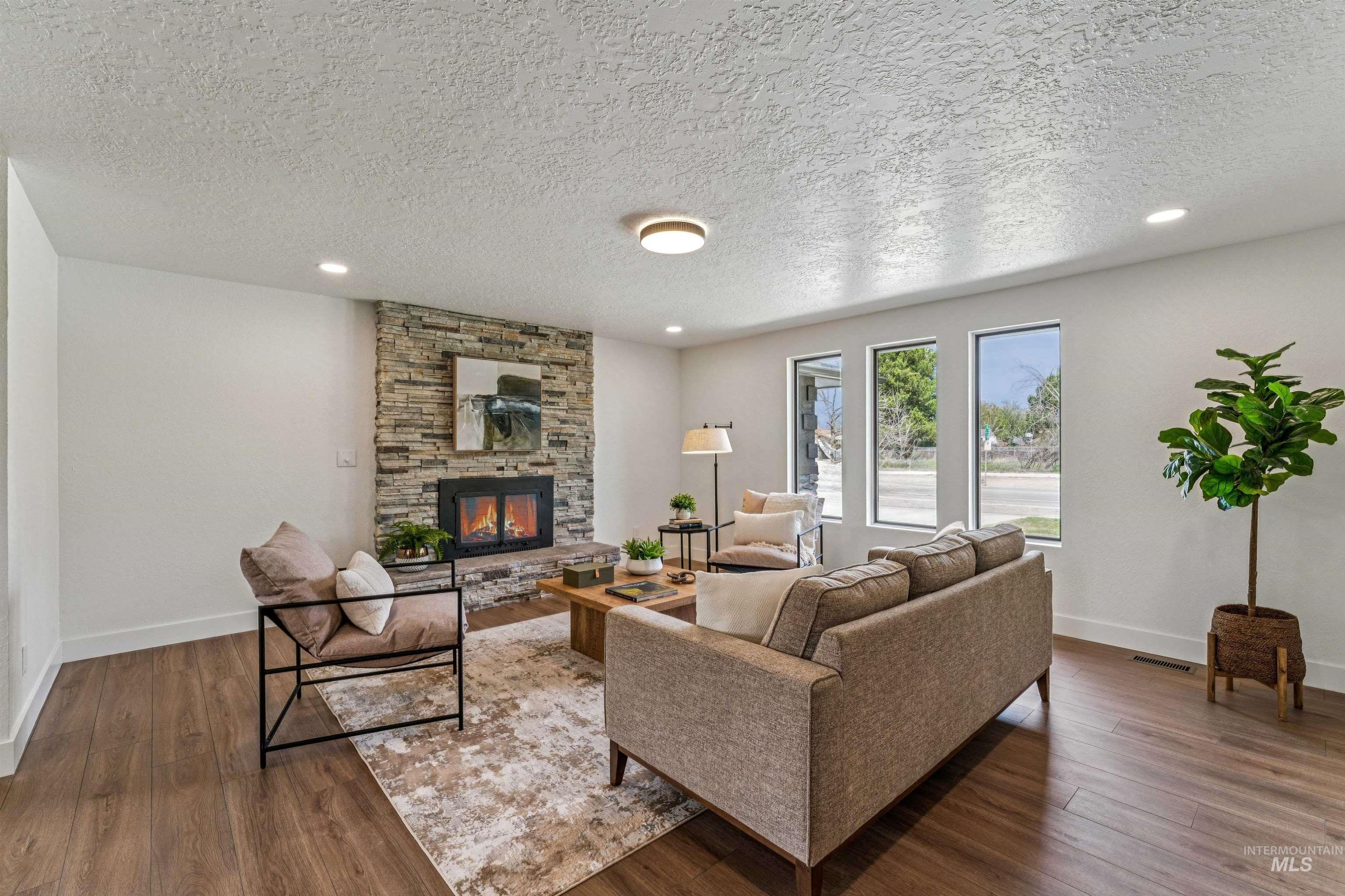 9709 West McMillan Road Boise, ID 83704 - Photo 7 of 50 Living area featuring a textured ceiling, recessed lighting, wood finished floors, and a fireplace