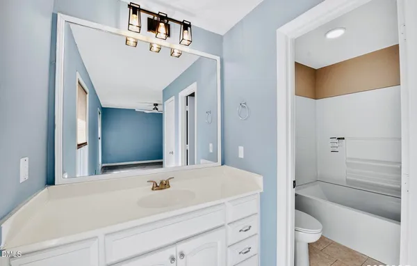 a spacious bathroom with a toilet sink and mirror