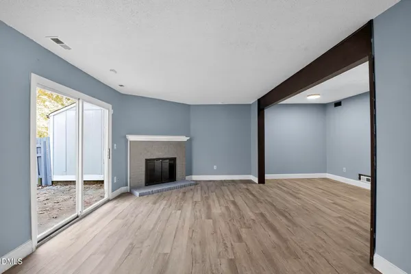 wooden floor fireplace and windows in an empty room