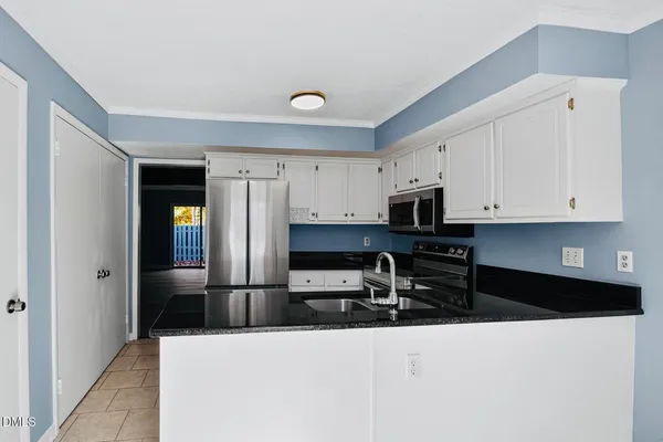 a kitchen with white cabinets and stainless steel appliances